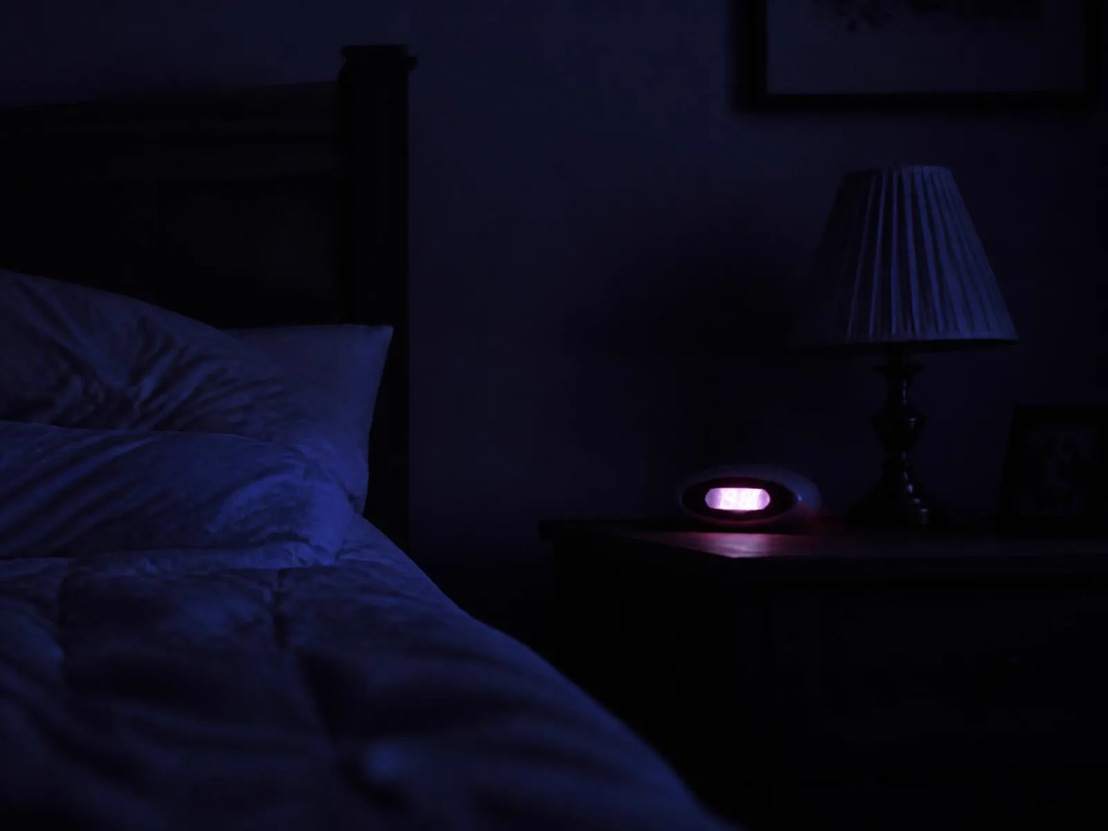 Rozsvietená nočná lampa pri posteli počas dlhého zaspávania